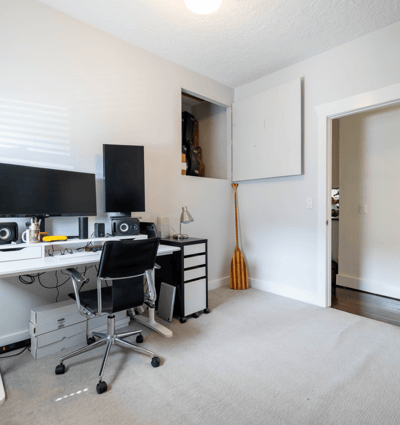Bright home office space featuring dual monitors, ample storage, and a practical layout for productivity.