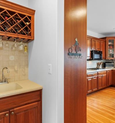 Butlers Pantry with convenient wine rack, glassware storage, wet bar, and prep area.
