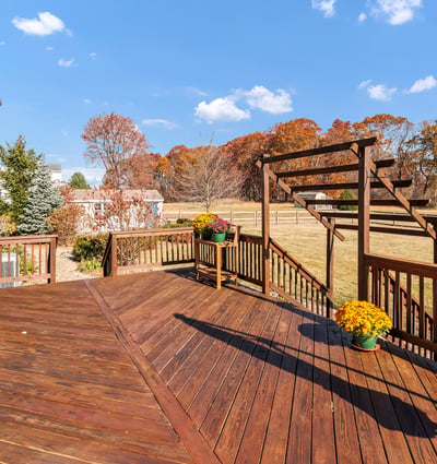 A paver walkway off the deck leads to the spacious fenced-in yard, paver patio, garden shed, and gate to the driveway.