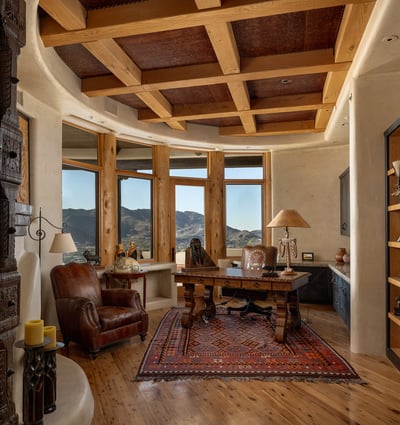 Command productivity and peace in this custom office retreat. Featuring built-in shelving, a rustic beamed ceiling, and a private patio framed by majestic mountain views, it blends inspiration with privacy in the heart of the home.