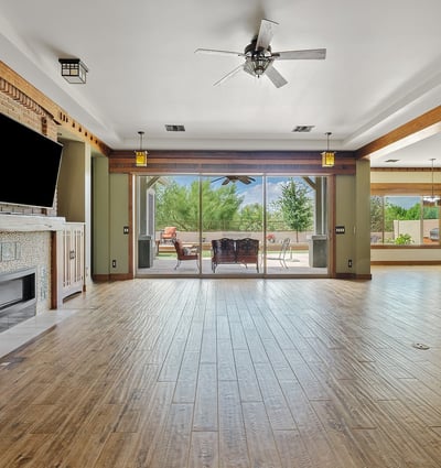 The open floor plan connects living spaces with warmth and elegance, featuring wood floors, beamed ceilings, and seamless transitions ideal for modern Phoenix living.