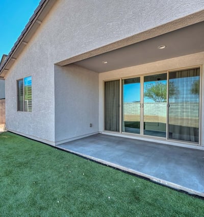 This covered patio is the perfect extension of indoor living ideal for shaded relaxation or hosting guests year-round. The smooth concrete flooring and direct access through sliding doors add comfort and convenience to this Peoria backyard retreat.