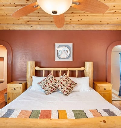 Primary bedroom featuring custom log furniture, warm wood tones, and a spacious layout designed for comfort and relaxation in Prescott.