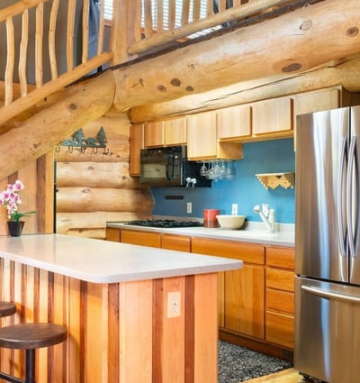 Detailed view of the kitchen island, modern appliances, and custom wood cabinetry that combine rustic charm with everyday functionality.
