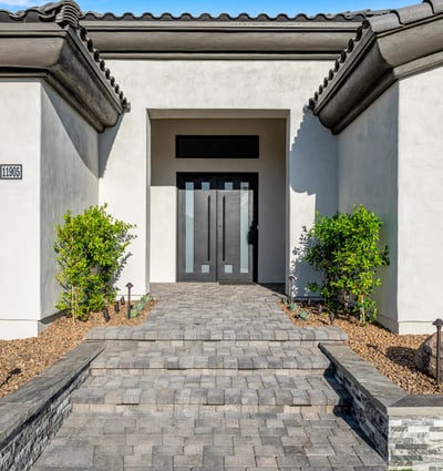 A modern stone-paved entry leads to sleek double doors, giving this Scottsdale property standout curb appeal.