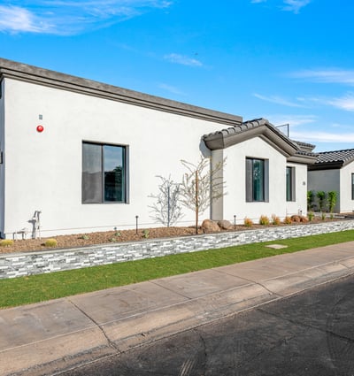 Modern desert-friendly landscaping with stone planters and fresh plantings frames the Scottsdale home. Perfect for low-water use and easy maintenance.
