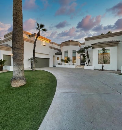 Beautiful modern architecture framed by palms and desert landscaping. The curved drive and tall windows make a bold Scottsdale impression.