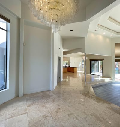 Dramatic entryway featuring a sparkling chandelier and open layout that flows effortlessly into the main living and kitchen spaces.