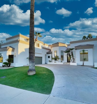 Stunning front approach with a grand circular driveway, manicured landscape, and contemporary exterior finishes.