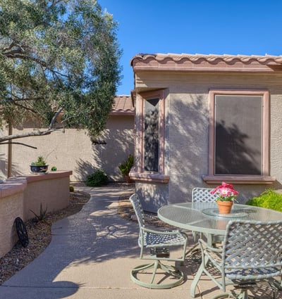 Gather under the Arizona sun in this inviting front patio with privacy walls and mature trees. A perfect outdoor retreat for morning coffee or evening relaxation.