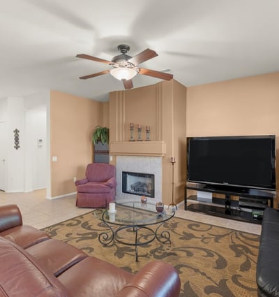 Cozy up by the gas fireplace in this elegant living area. Large windows and earthy tones create a comfortable setting for relaxing evenings at home.
