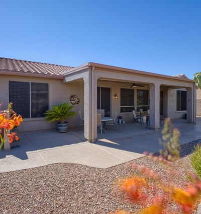 The large covered patio provides shade and comfort for outdoor dining or lounging. Surrounded by vibrant desert plants and private views.
