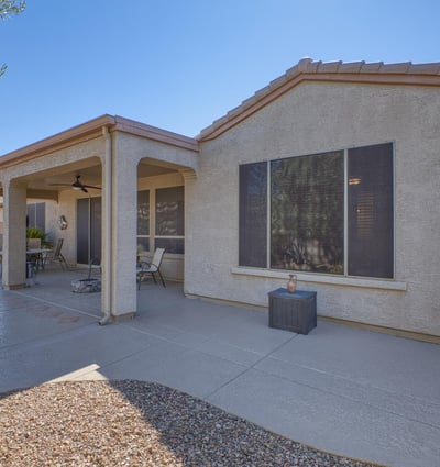 An extended patio designed for entertaining with ceiling fan, lighting, and plenty of space for seating under the Arizona sky.