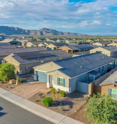 A wide aerial angle highlighting the home surrounded by beautiful mountain views and a peaceful residential setting. The property stands out with its curb appeal, energy-efficient build, and attractive desert landscaping.