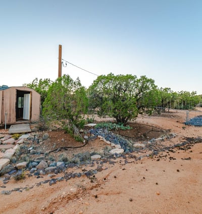 Expansive open space with mature vegetation offers endless possibilities for outdoor activities, workspaces, or creative land use on this Hackberry retreat.