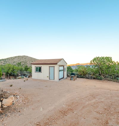 A functional workshop sits against a backdrop of scenic mountains, providing useful storage or project space with unmatched Hackberry views.