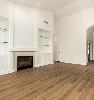 Elegant Scottsdale living space featuring custom built-in shelving surrounding a cozy fireplace. The clean white cabinetry and modern flooring add both style and storage to this beautifully updated interior.