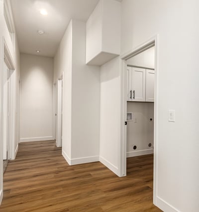 Bright hallway with updated flooring and neutral finishes connecting the living areas and bedrooms of this Scottsdale home. High ceilings and clean architectural lines enhance the spacious feel of the remodeled interior.