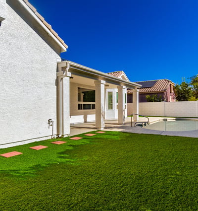 Large Scottsdale backyard combining a manicured lawn with a private pool and covered patio. The outdoor space offers room for entertaining, recreation, and peaceful relaxation.