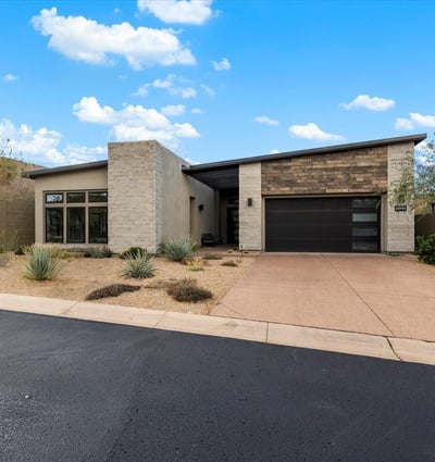 Contemporary Scottsdale exterior showcasing refined materials, clean lines, and desert-inspired landscaping. A striking example of modern luxury design in a gated community.