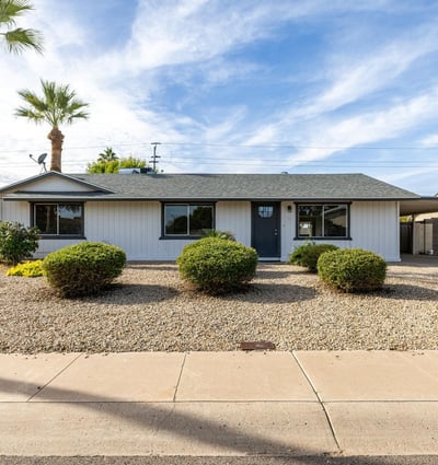 Welcoming Phoenix exterior with mature landscaping, low-maintenance gravel yard, and a charming entry great curb appeal for buyers seeking a move-in-ready home.
