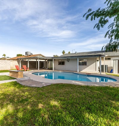 Private backyard escape featuring a sparkling pool, covered patio shade, and plenty of space to unwind enjoy outdoor comfort and entertaining in Phoenix.