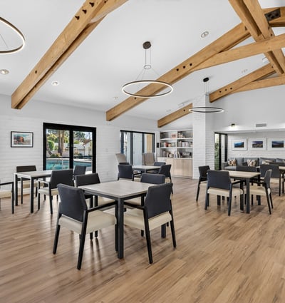 Expansive clubhouse interior with dining tables and lounge areas, ideal for hosting and connecting with neighbors.
