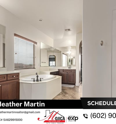 This expansive primary bathroom showcases dual vanities, soaking tub, and separate shower. Tile flooring and ample cabinetry enhance the comfort of this Glendale home with granite kitchen and pool.