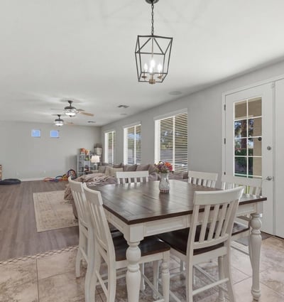 Dining area with elegant pendant lighting and French doors providing access to the backyard pool and outdoor living area.