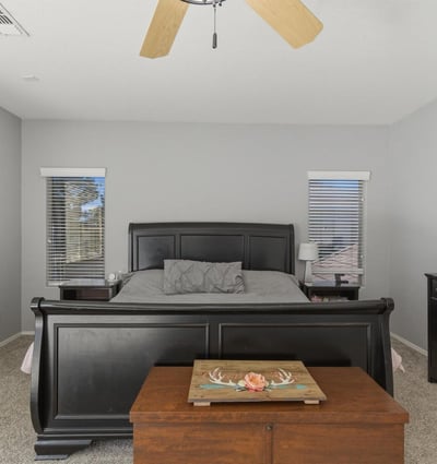 Bright primary bedroom with neutral finishes, ceiling fan, and expansive floor space offering comfort and versatility within the home s upper level.