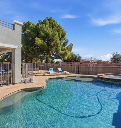 Sparkling backyard pool with spa, stone decking, and lounge space surrounded by mature trees for added privacy and shade.