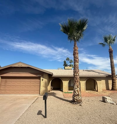 Beautiful exterior view of this Glendale property featuring mature palm trees, desert landscaping, and durable block construction. The home offers strong curb appeal with a welcoming front driveway and garage.