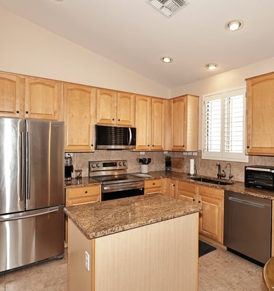Kitchen with abundant cabinetry, granite surfaces, and stainless steel appliances. This Phoenix property offers both style and storage for modern living.