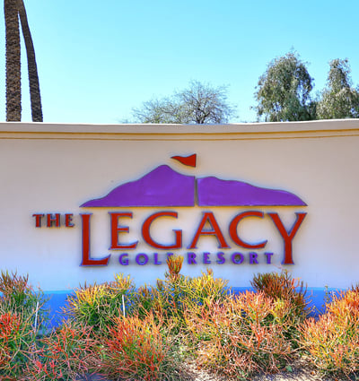 The Legacy Golf Resort sign set among desert plants and clean hardscape. This Phoenix location offers access to golf, recreation, and scenic surroundings.