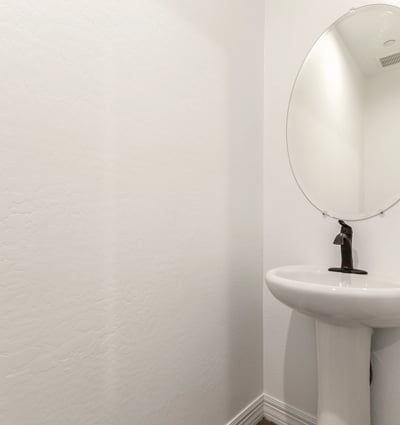 Clean and modern guest bathroom with pedestal sink and updated fixtures, offering convenience and style for visitors.