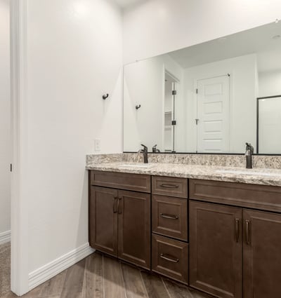 Primary bathroom with dual vanities, granite surfaces, and ample storage. A blend of style and everyday functionality.