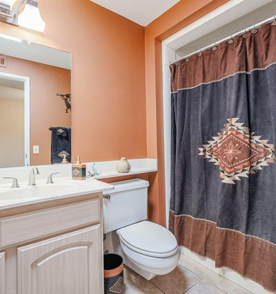 Guest bathroom featuring tub/shower combo, spacious vanity, and warm tones, offering both style and practicality.