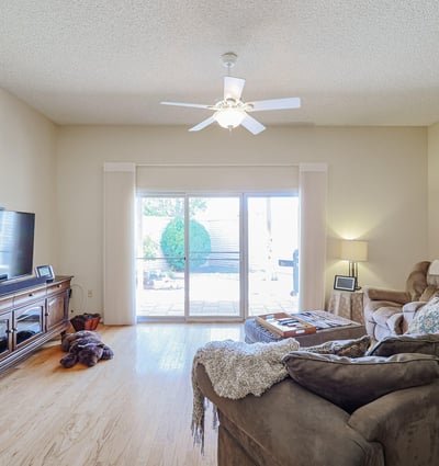 Light-filled living room with sliding doors to the backyard patio, hardwood floors, and open layout for comfortable living.