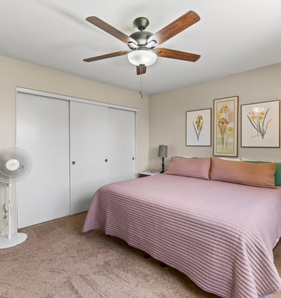 Comfortable primary bedroom with ceiling fan, plush carpet, and neutral finishes. A relaxing space designed for everyday living.