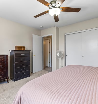 Bright primary suite with dual closets, ceiling fan, and convenient access to the bathroom. A functional and inviting layout.