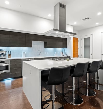 Sleek kitchen featuring a large island, stainless steel appliances, and open layout, designed for both everyday living and entertaining.