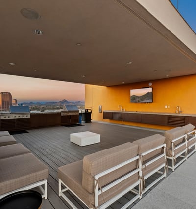 Stylish rooftop entertainment area featuring built-in grills, seating, and open-air design, ideal for hosting in Phoenix.