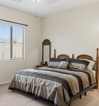 Inviting primary bedroom with large window, soft natural light, and neutral finishes, offering a peaceful retreat in this Phoenix home.