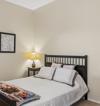 Bright secondary bedroom with window views, neutral tones, and flexible use for guests or family in this Phoenix home.