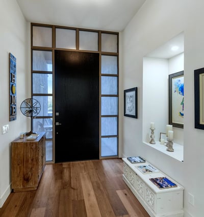 Modern entry with tall ceilings, wood flooring, and striking front door design, creating a welcoming arrival experience in Phoenix.