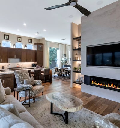 Open living area featuring a sleek fireplace, built-in shelving, and connection to the kitchen for easy entertaining in Phoenix.