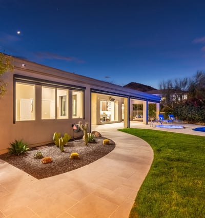 Bright covered patio opening to a lush backyard with pool and landscaping, showcasing seamless Scottsdale indoor-outdoor living.