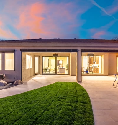 Inviting Scottsdale backyard featuring manicured grass, covered patio, and pool access, perfect for relaxing or entertaining in a private outdoor setting.