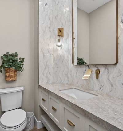 Elegant powder room with updated vanity, quartz countertop, decorative backsplash, and modern lighting in this Scottsdale residence.