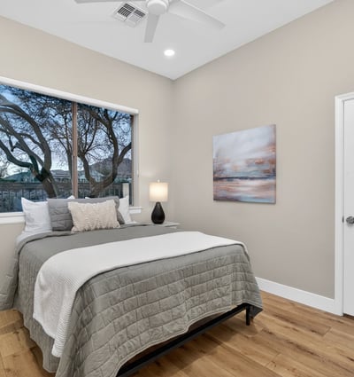 Peaceful Scottsdale bedroom with expansive window views, modern finishes, and wood flooring, ideal for relaxation.